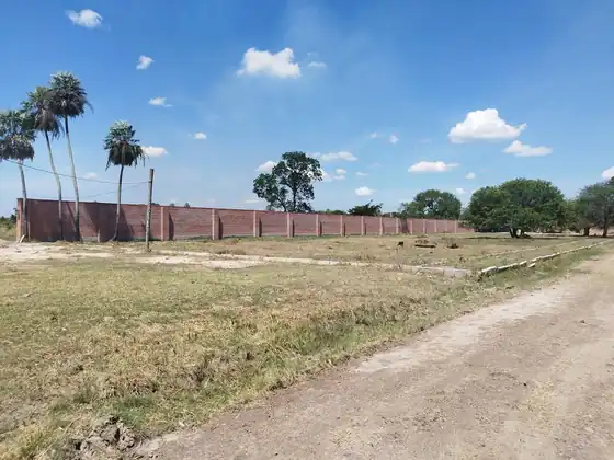 Loteamiento cerrado con muro perimetral de ladrillo y calle interna de tierra